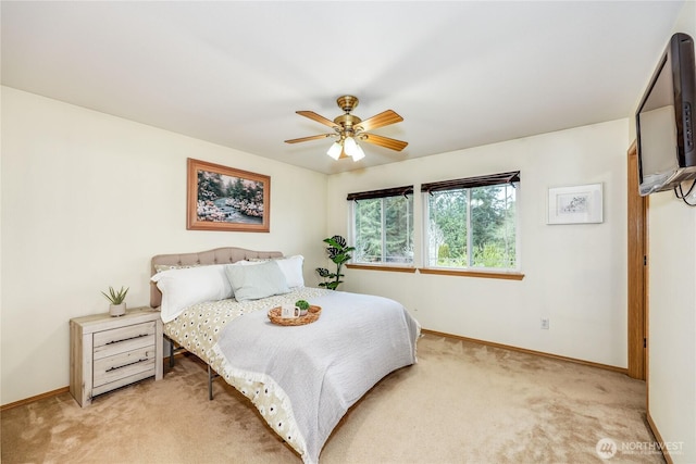 bedroom with light colored carpet, baseboards, and a ceiling fan
