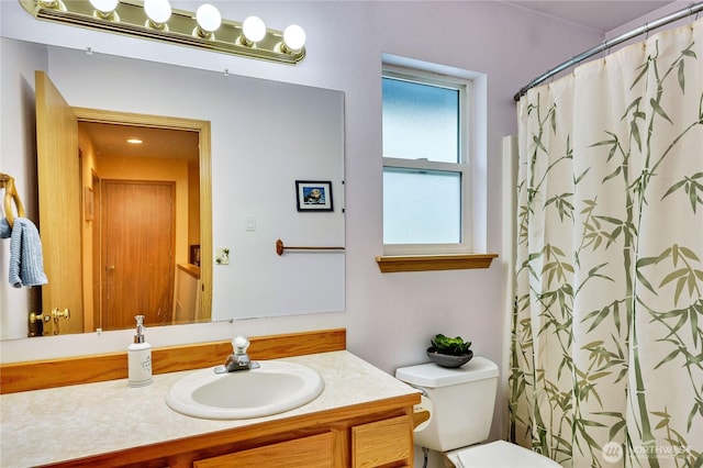 full bathroom featuring a shower with shower curtain, vanity, and toilet