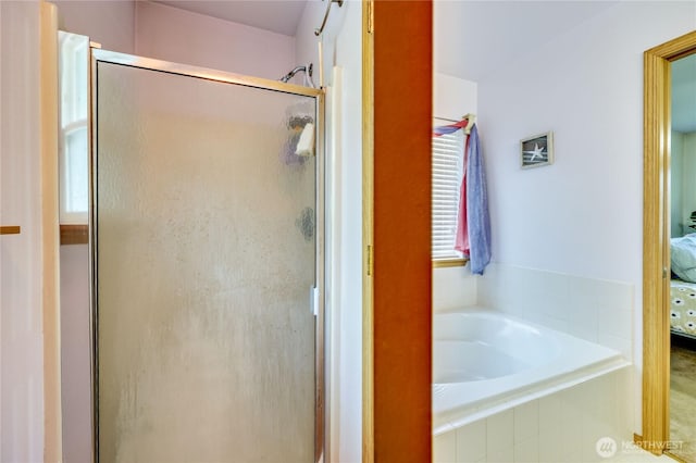 full bath featuring ensuite bathroom, a bath, and a stall shower