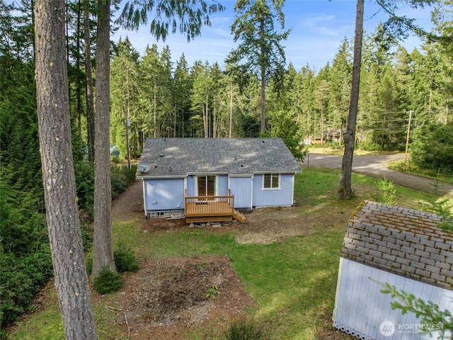 12802 Silver Dr, Anderson Island, WA 98303 - rear view of house featuring a wooded view, crawl space, a wooden deck, a yard, and a shingled roof