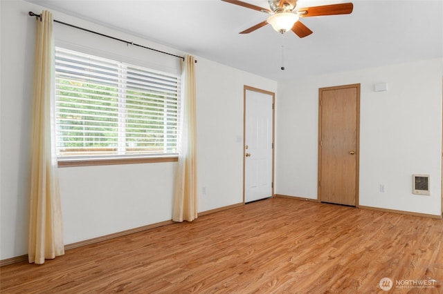 12802 Silver Dr, Anderson Island, WA 98303 - unfurnished bedroom featuring light wood-style floors, ceiling fan, baseboards, and heating unit