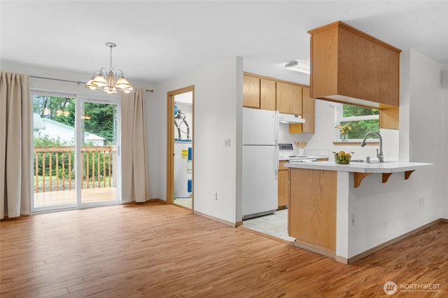 12802 Silver Dr, Anderson Island, WA 98303 - kitchen featuring white appliances, a peninsula, a sink, light countertops, and electric water heater