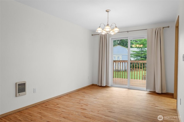 12802 Silver Dr, Anderson Island, WA 98303 - spare room with wood finished floors, a notable chandelier, baseboards, and heating unit