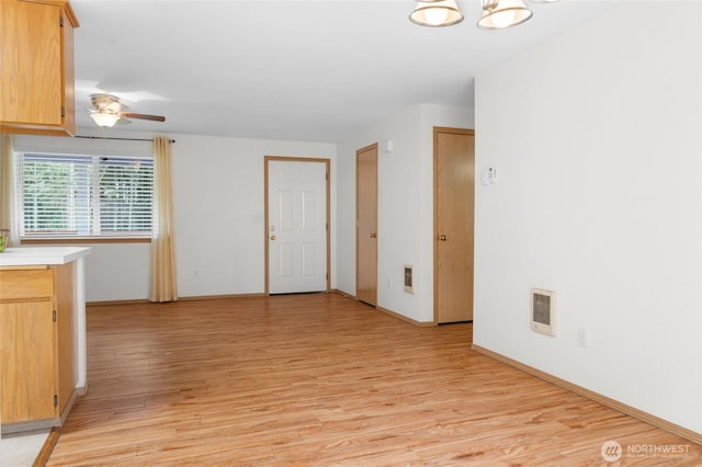 12802 Silver Dr, Anderson Island, WA 98303 - interior space featuring visible vents, light brown cabinets, light countertops, light wood finished floors, and ceiling fan with notable chandelier