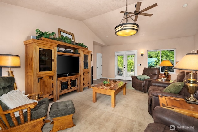 living room with lofted ceiling, french doors, a ceiling fan, and light carpet