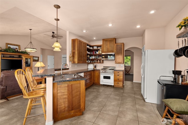 kitchen with a sink, open shelves, brown cabinetry, gas range, and arched walkways