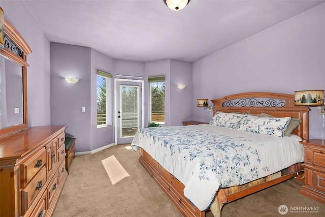 bedroom with light colored carpet, access to exterior, and baseboards