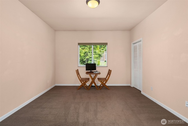 unfurnished room with baseboards and dark carpet