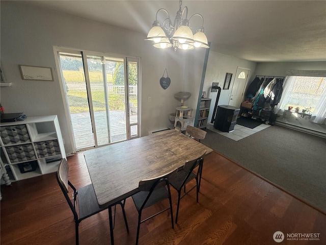 dining room with wood finished floors, a chandelier, and baseboard heating