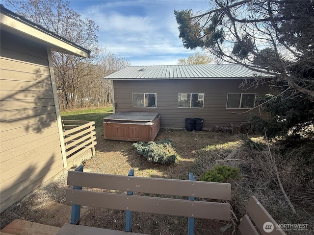 view of home's exterior with metal roof and fence