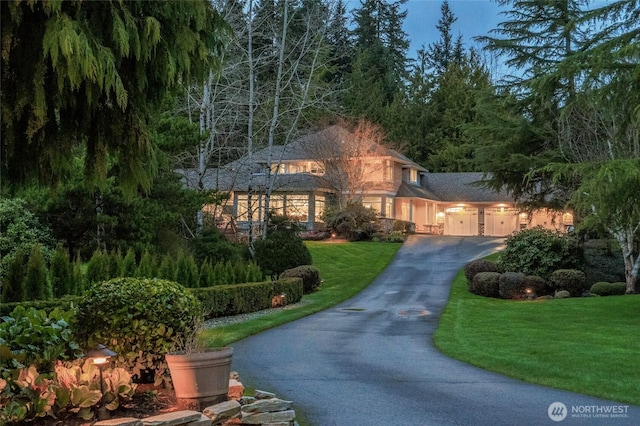 view of front of property with a front yard, an attached garage, and aphalt driveway