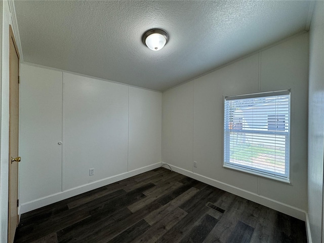 181A-B Beacon Hill Dr, Longview, WA 98632 - unfurnished room featuring dark wood-style floors, lofted ceiling, a textured ceiling, baseboards, and a decorative wall