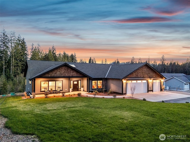 view of front facade with an attached garage, a shingled roof, a front lawn, and concrete driveway