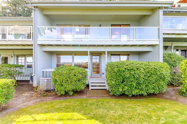 rear view of property featuring a balcony and central AC