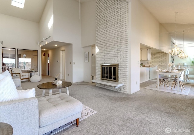 living room with a chandelier, a brick fireplace, and light colored carpet