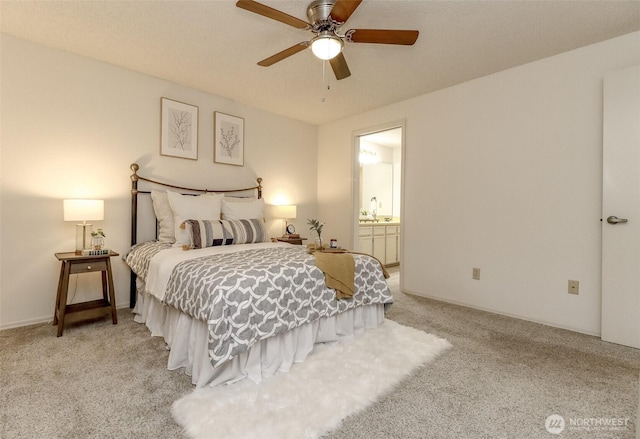 carpeted bedroom featuring ensuite bathroom, a sink, and a ceiling fan