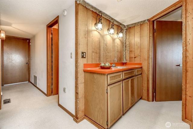 bathroom featuring visible vents, wooden walls, and a textured ceiling