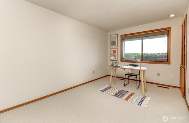 home office with light carpet, baseboards, and visible vents