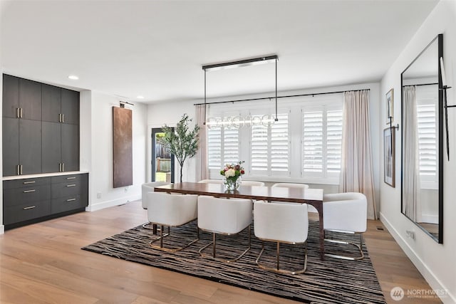 dining room with baseboards, light wood-style flooring, and recessed lighting