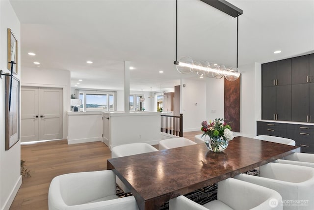 dining area featuring baseboards, light wood-style flooring, and recessed lighting