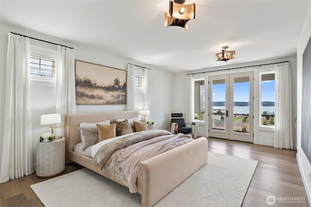 bedroom with french doors, access to exterior, and wood finished floors