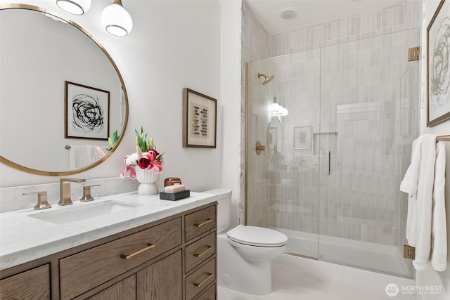 full bathroom featuring toilet, vanity, and a stall shower