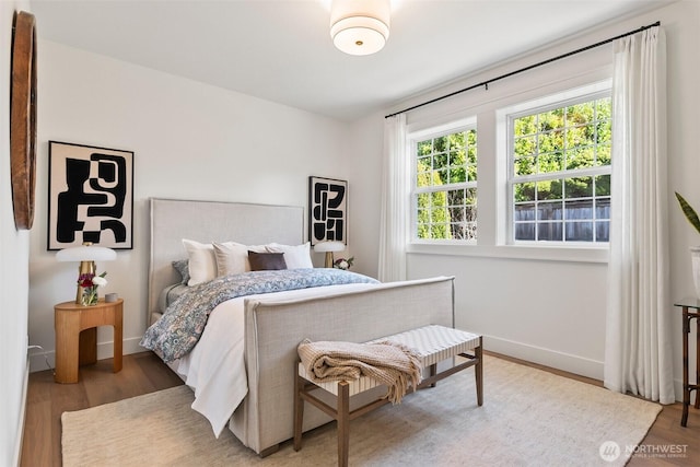 bedroom featuring baseboards and wood finished floors