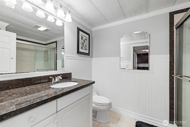 full bathroom with tile patterned flooring, ornamental molding, a shower stall, a wainscoted wall, and visible vents