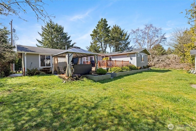 rear view of property with a lawn and a gazebo