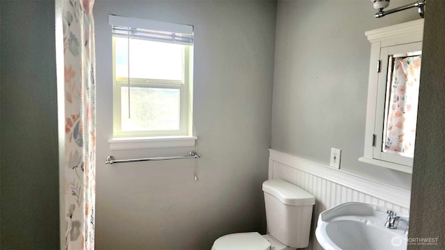 485 SW Bayshore Dr Unit C301, Oak Harbor, WA 98277 - full bathroom featuring toilet, a sink, and a wainscoted wall