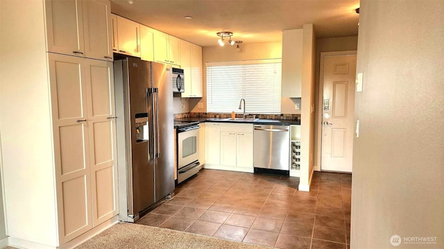 485 SW Bayshore Dr Unit C301, Oak Harbor, WA 98277 - kitchen featuring tile patterned floors, dark countertops, a sink, and appliances with stainless steel finishes