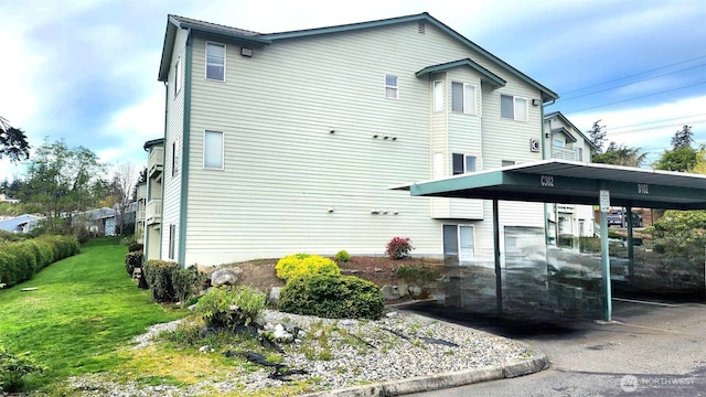 485 SW Bayshore Dr Unit C301, Oak Harbor, WA 98277 - view of property exterior featuring a yard and covered parking