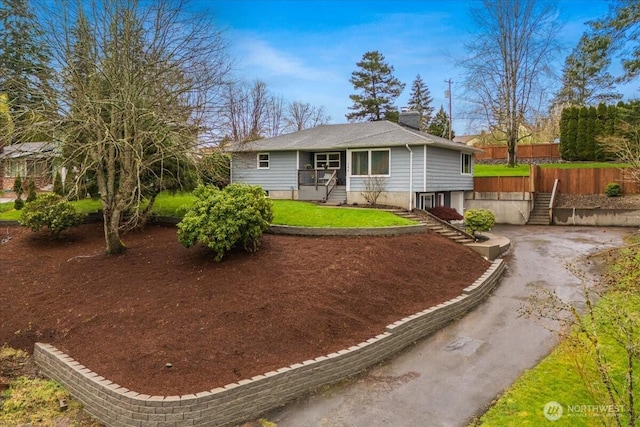 ranch-style home with entry steps, a front yard, and fence