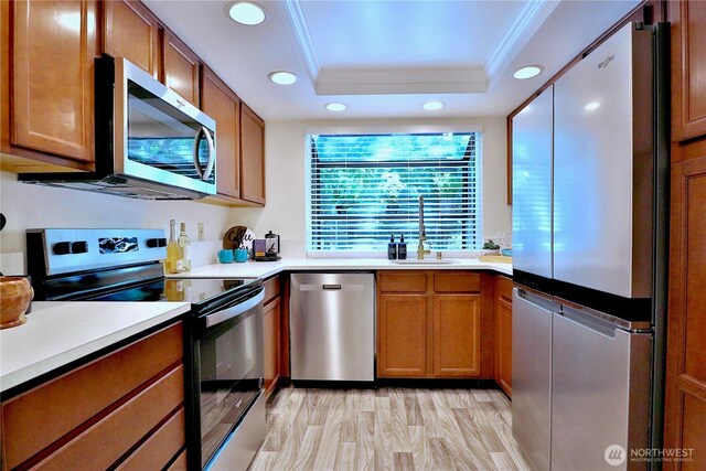 11500 NE 128th St Unit 48, Kirkland, WA 98034 - kitchen with appliances with stainless steel finishes, a sink, ornamental molding, a raised ceiling, and brown cabinets