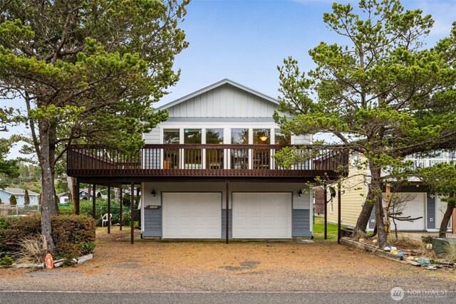 view of front of house with driveway, a garage, and a deck