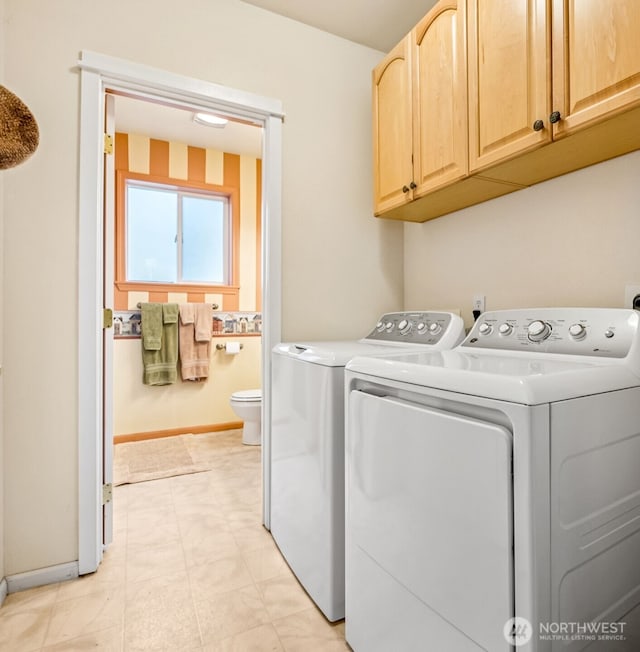 laundry room with independent washer and dryer, cabinet space, and baseboards