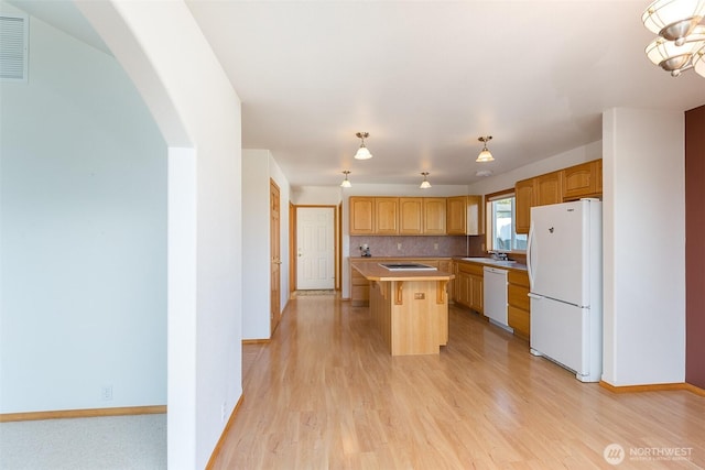 305 W Eunice St, Sequim, WA 98382 - kitchen featuring a sink, a kitchen island, arched walkways, light wood-type flooring, and white appliances