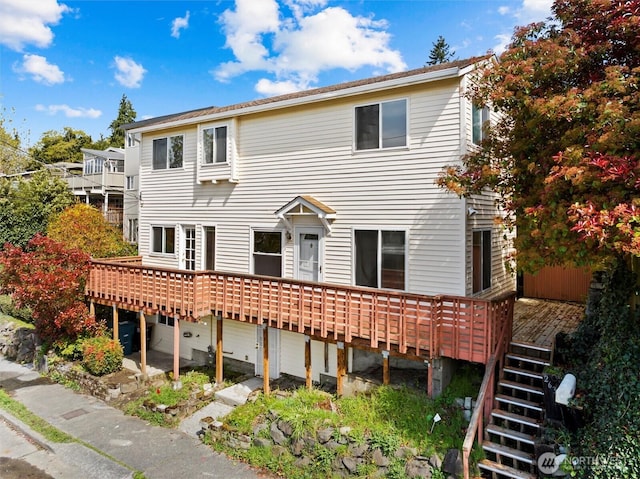 back of property with a wooden deck and stairway