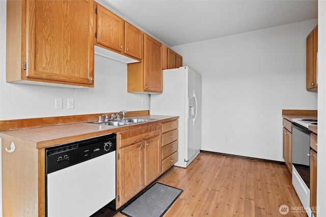 kitchen with a sink, light wood-type flooring, baseboards, white appliances, and brown cabinetry