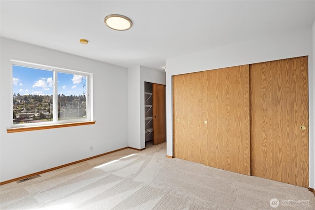 unfurnished bedroom with baseboards, a closet, visible vents, and carpet