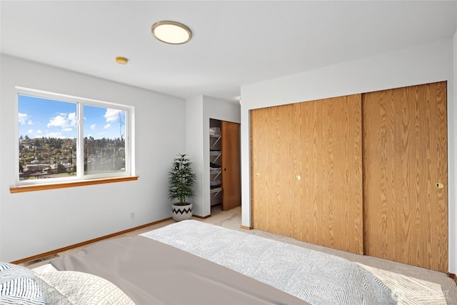 carpeted bedroom with baseboards and a closet