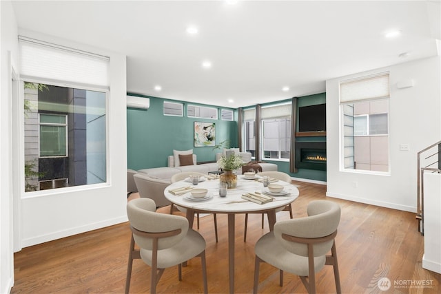 2620 SW Nevada St, Seattle, WA 98126 - dining space with recessed lighting, a wall unit AC, wood finished floors, and a warm lit fireplace