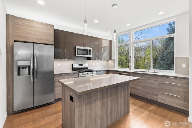 2620 SW Nevada St, Seattle, WA 98126 - kitchen featuring wood finished floors, tasteful backsplash, a sink, and appliances with stainless steel finishes