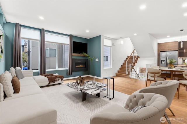 2620 SW Nevada St, Seattle, WA 98126 - living room with light wood finished floors, recessed lighting, a warm lit fireplace, and stairs
