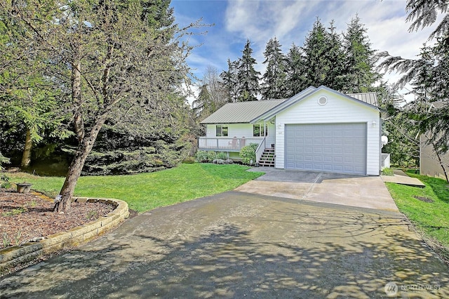 ranch-style home with a porch, metal roof, a front lawn, an attached garage, and concrete driveway