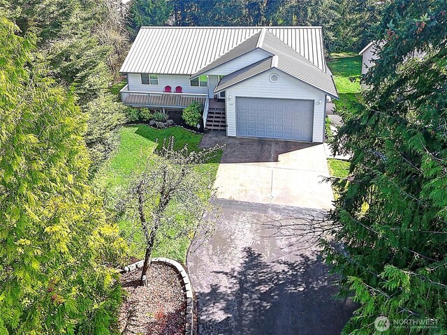 1637 Poplar Ln, Camano Island, WA 98282 - view of front facade with concrete driveway, metal roof, a garage, and a front yard