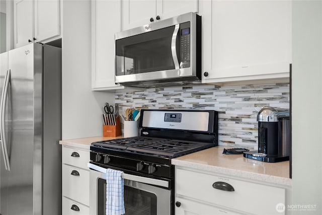 78 Pacifica Ln, Pacific Beach, WA 98571 - kitchen featuring white cabinets, decorative backsplash, appliances with stainless steel finishes, and light stone countertops