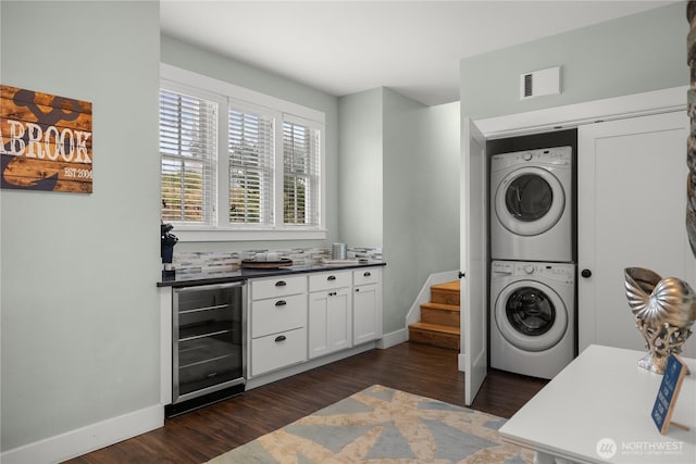 78 Pacifica Ln, Pacific Beach, WA 98571 - clothes washing area with stacked washer and clothes dryer, dark wood-style flooring, beverage cooler, visible vents, and laundry area