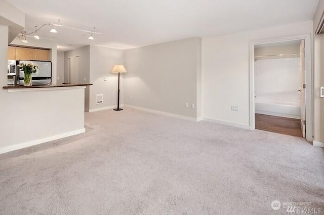 108 5th Ave S Unit 520, Seattle, WA 98104 - unfurnished living room featuring baseboards, visible vents, and light carpet