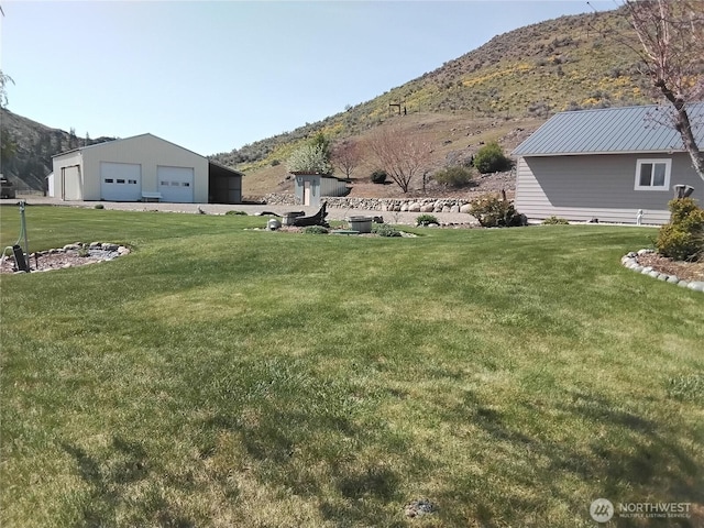 view of yard featuring a mountain view and a detached garage